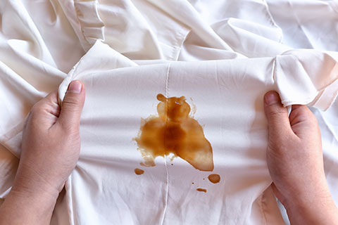 Reinigen im Haushalt: Wie den Schmutz am wirkungsvollsten bek&auml;mpfen? Bild: Hand mit gelbem Putzhandschuh und rosa Putztuch macht Reinigungsbewegung auf einer glatten Oberfl&auml;che. Foto: Africa-Studio/Shutterstock.com